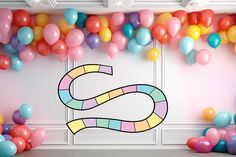 a room with balloons and streamers in the shape of a snake on the wall