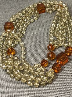 "Rare Retro Three Strand, Extra Long, Highly Faceted Round and Cubed Lucite Bead Necklace, 44\" Long, c. 1960s-70s. Stunning triple strand, extra long at 44\" inches, a mix of lucite clear faceted round beads and gold-colored cubes.   In very good vintage condition. Check out my other vintage jewelry for more amazing prices! Check out my other vintage jewelry for more amazing prices!" Vintage Beaded Necklaces With Colorful Beads, Vintage Faceted Beaded Necklace, Vintage Formal Beaded Necklaces With Faceted Beads, Vintage Orange Beaded Necklaces For Formal Occasions, Vintage Multi-strand Colorful Beaded Necklaces, Vintage Multi-strand Beaded Necklace With Colorful Beads, Vintage Single Strand Beads For Formal Occasions, Vintage Multi-strand Beaded Necklaces With Colorful Beads, Vintage Single Strand Beads For Jewelry Making