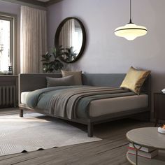 a living room scene with focus on the bed and round mirror hanging above it's headboard