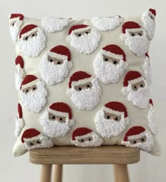 a santa clause pillow sitting on top of a wooden chair