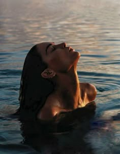 a woman is floating in the water with her eyes closed and head tilted to the side