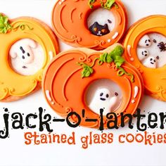 four decorated cookies in the shape of jack - o - lantern pumpkins with ghost faces