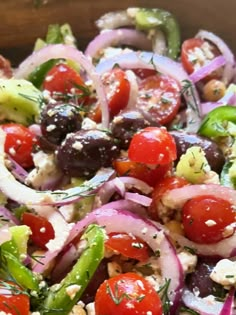 a salad with tomatoes, onions, cucumbers and olives