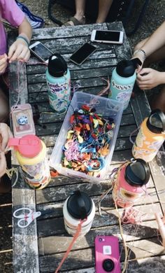 several people sitting around a table with drinks and candy in containers on top of it