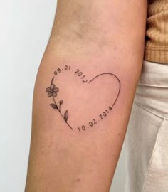 a woman's arm with a tattoo on it that says love and flowers in the shape of a heart