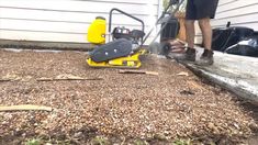 a man using a chainsaw to cut up wood chips in front of a house