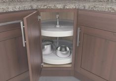 an open cabinet with pots and pans in it