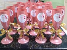 pink goblets with gold bows and labels on them