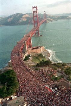 an aerial view of the golden gate bridge in san francisco, california with hundreds of people gathered around it