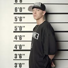 a man standing in front of a mugshot wall with his hands on his hips