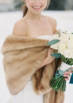 a woman in a fur stole holding a bouquet