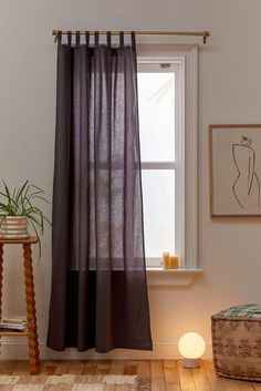 an image of a window with curtains on the side and a light next to it