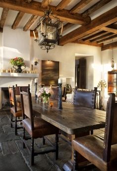 a dining room table and chairs in front of a fireplace