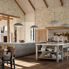 a large kitchen with wooden floors and stone walls