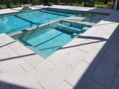 an empty swimming pool surrounded by grass and trees