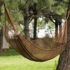 a hammock hanging from a tree in the grass