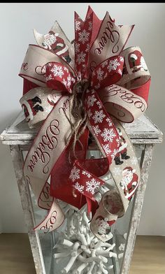 a red and white christmas decoration with snowflakes on the top is hanging from a lantern