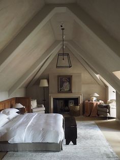 an attic bedroom with a bed and fireplace