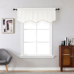 a living room with a chair, window and pictures hanging on the wall above it