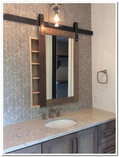 a bathroom with a sink, mirror and lights on the wall above it's counter