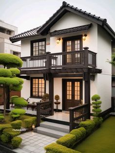 a white and black house with trees in the front yard