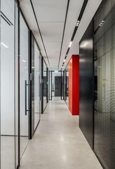 an empty hallway with red and black doors