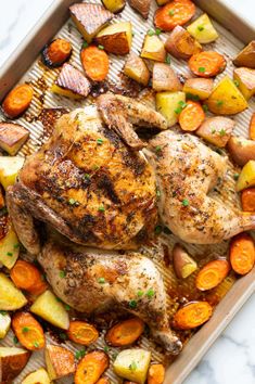 chicken, potatoes and carrots on a baking sheet