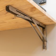 a close up of a wooden shelf with some metal brackets on the top and bottom