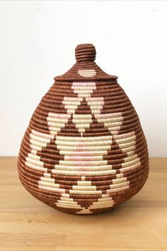 a brown and white basket sitting on top of a wooden table