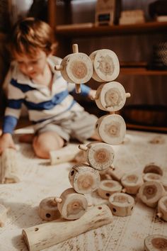 a young boy playing with wooden toys on the floor