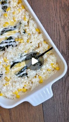 a casserole dish filled with rice, corn and other toppings on a wooden table