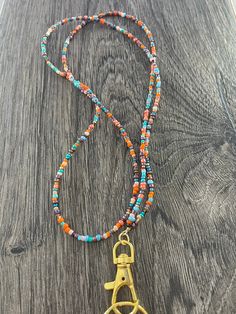 "I call this color combination of beads \"Turquoise Harvest\". This beautiful lanyard is made with hand selected glass seed beads. It is very lightweight and comfortable to wear. We do custom designs also! Lanyards can be used to hold work or school ID badges, eyeglasses or sunglasses, keys, flash drives, life alert sensors, or whatever else you wish! They make wonderful gifts for teachers, hospital workers, and corporate employees. Available in 2 sizes: 34\" or 37\". Picture shown on model (5'7 Turquoise Beaded Chain For Beach, Glass Bead Keychain, Turquoise Lariat Beaded Necklace, Bohemian Beaded Necklace With Lobster Clasp, Colorful Beads Lariat Necklace For Beach, Turquoise Lariat Beaded Necklace With Colorful Beads, Multicolor Bohemian Beaded Necklace, Multicolor Lariat Beaded Necklaces For Beach, Multicolor Lariat Beaded Necklace For Beach