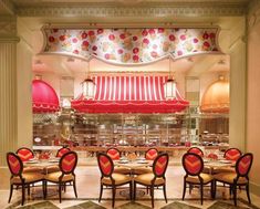 the interior of a restaurant with red and white striped awnings over tables set for four