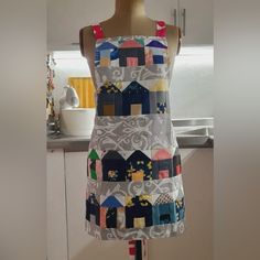 a mannequin wearing a dress made out of colorful fabric with houses on it