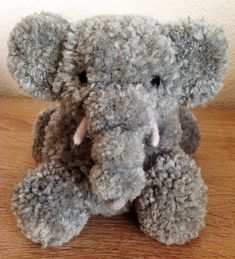 an elephant stuffed animal sitting on top of a wooden table