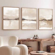 three paintings hang on the wall in a living room