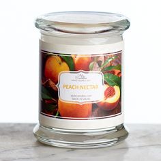 a glass jar filled with peach nectar sitting on top of a counter