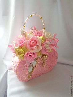 a pink purse with flowers and pearls on the handle