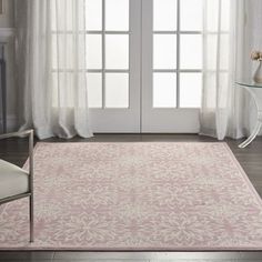 a pink and white rug in front of a window