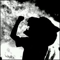 the silhouette of a man raising his fist up in front of a black and white background