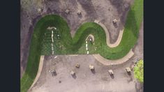 an aerial view of some cars parked in a parking lot with grass on the ground