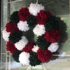 a red and white wreath hanging from the side of a window