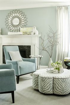 a living room filled with furniture and a fire place in front of a mirror on the wall