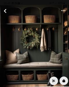 a bench with some baskets on it and a wreath hanging from the wall behind it