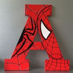 the letter a is made up of spiderman's web - covered letters, and sits on a table