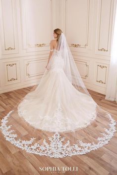 a woman in a wedding dress is standing on the floor with her veil over her head