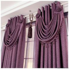 purple curtains with beaded trim and tassels hanging on the window sill