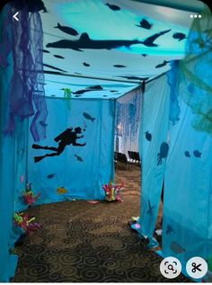 an underwater themed room with blue drapes and fish on the walls, under water