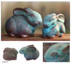 two ceramic rabbits sitting next to each other on top of a wooden table, one is blue and the other is brown