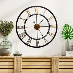 a clock on the wall next to a plant and potted plants in vases